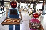 Robot couple Xiaolan and Xiaotao carry food at a restaurant in Jinhua